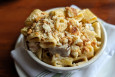 A bowl of mac and cheese features thick rigatoni topped in creamy cheese and biscuit crumbs.