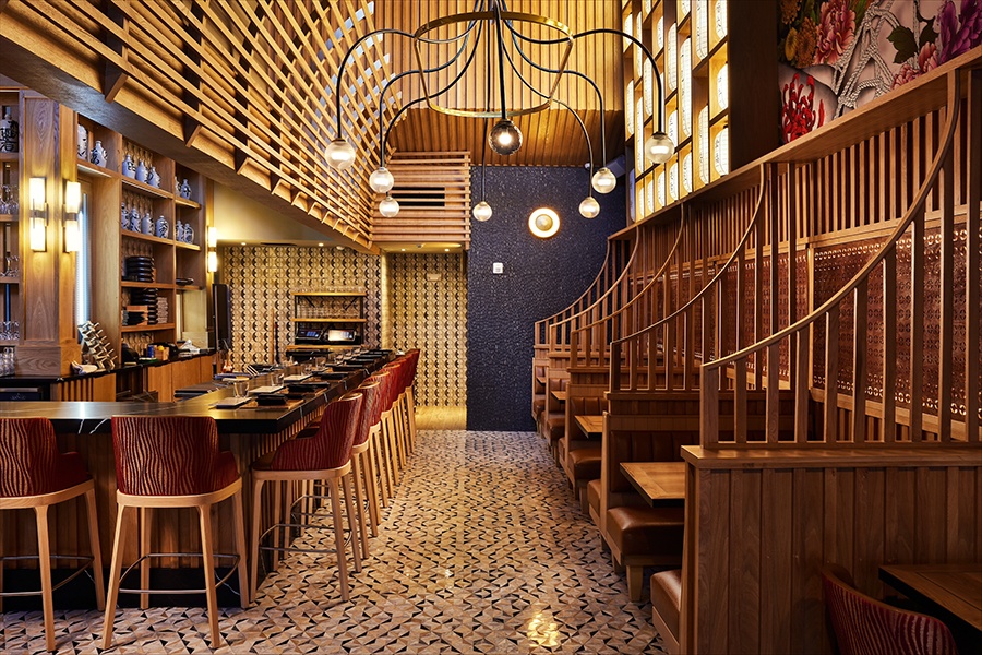 Interior of a Japanese restaurant with lots of elaborate woodworking and lanterns.