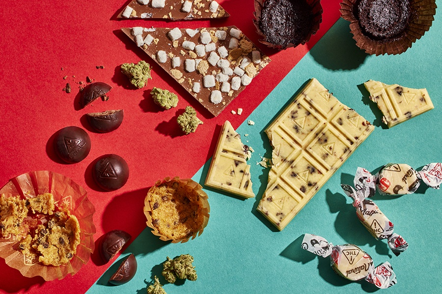 Overhead view of an assortment of infused chocolate bars, baked goods, and other edibles.