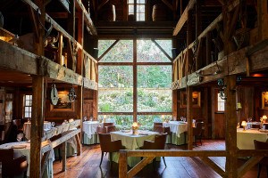A rustic-yet-elegant barn dining room features a giant picture window.