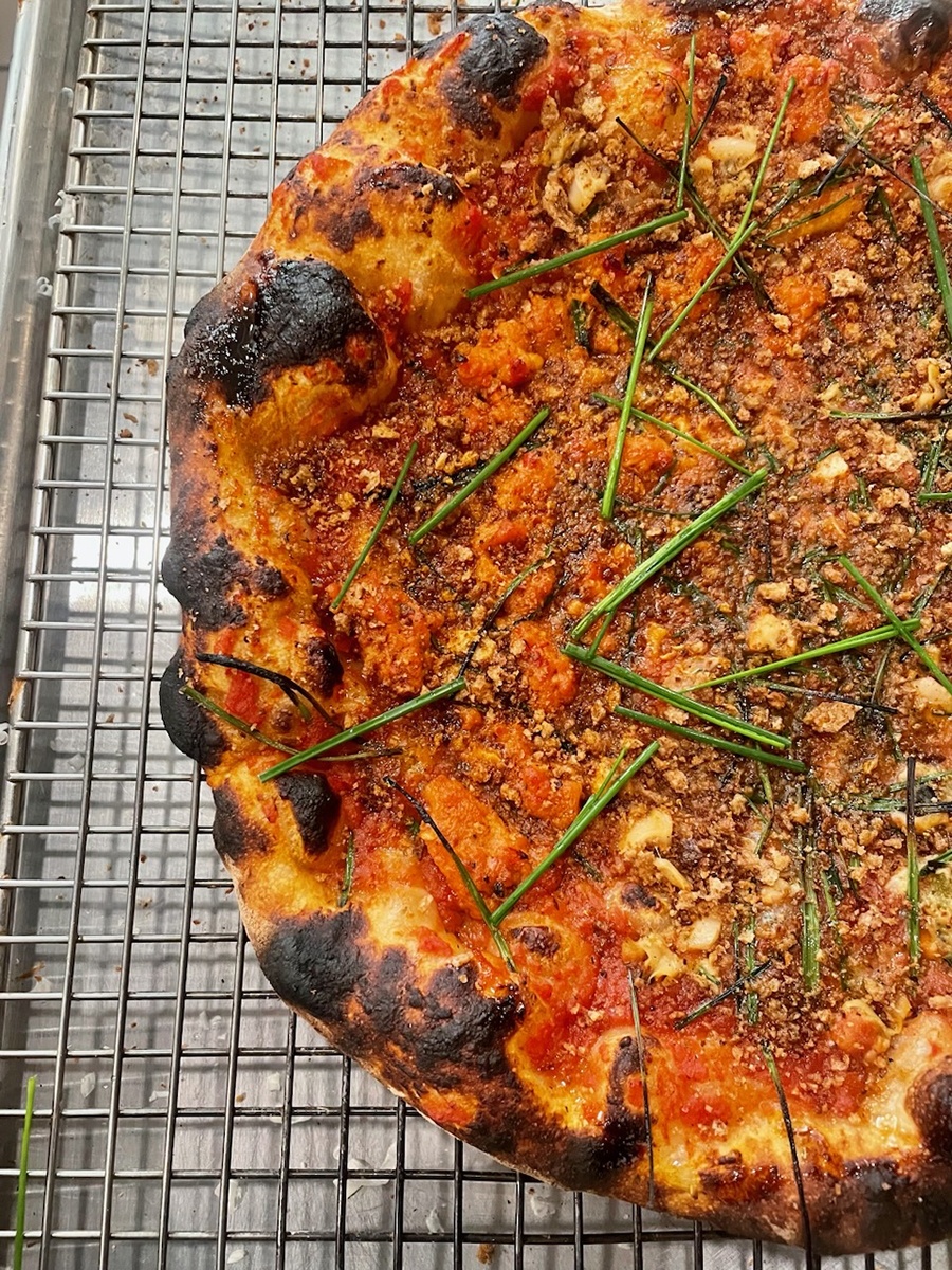 Overhead view of a pizza with a charred, bubbly crust.