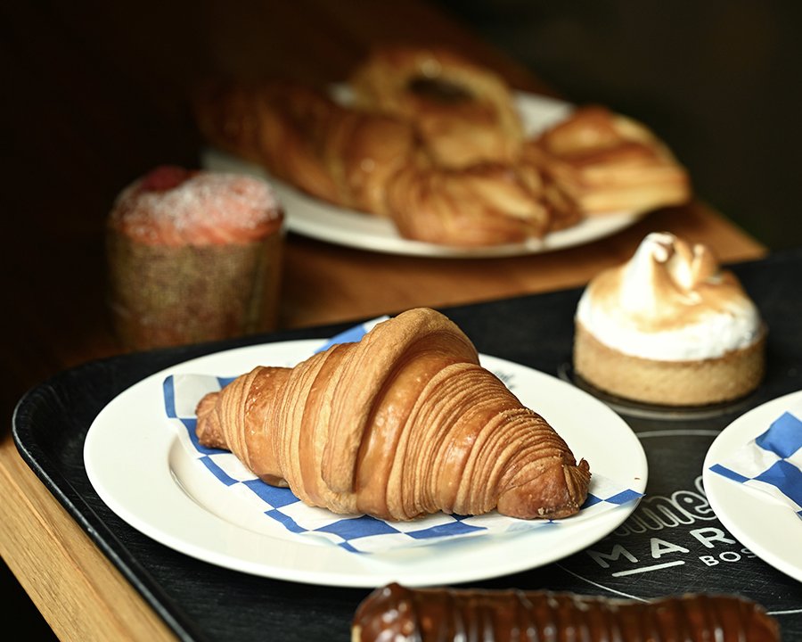 A croissant and other French pastries sit on a tray.