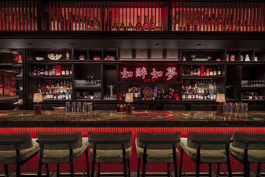 A restaurant bar features black marble, red accents, and neon Chinese characters.