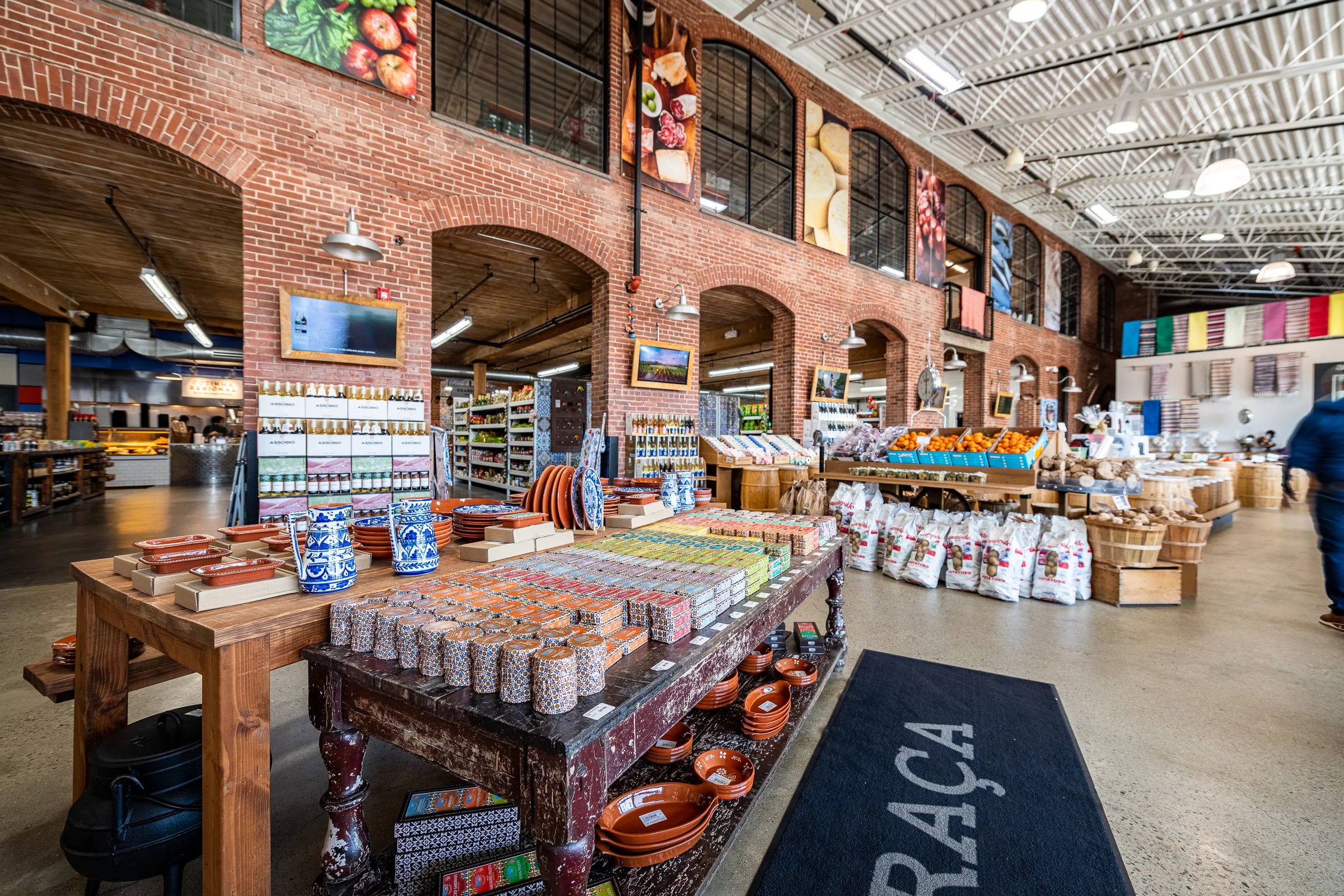 Interior of a high-ceilinged market with dramatic brick archways and loads of Portuguese goods.