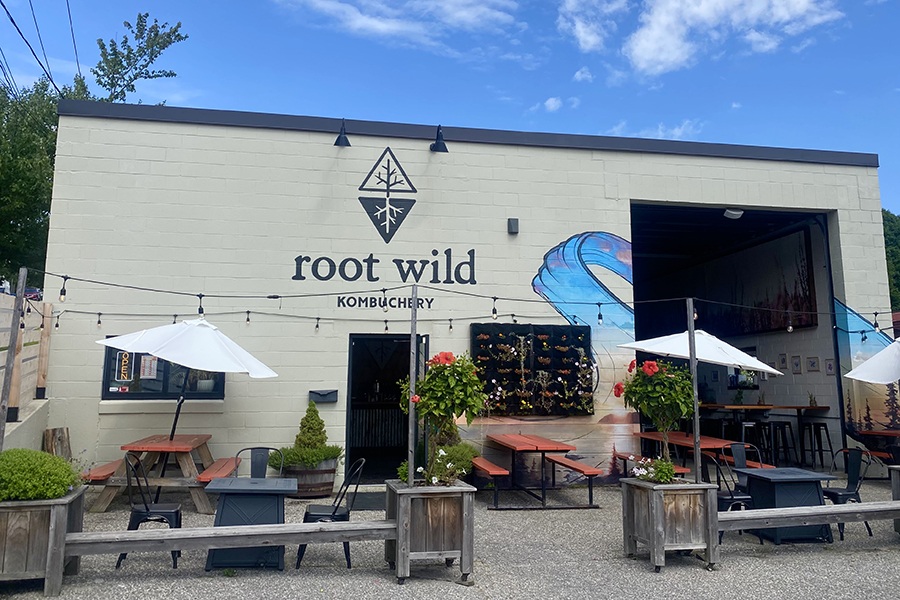 Exterior of a kombucha taproom with a patio out front.