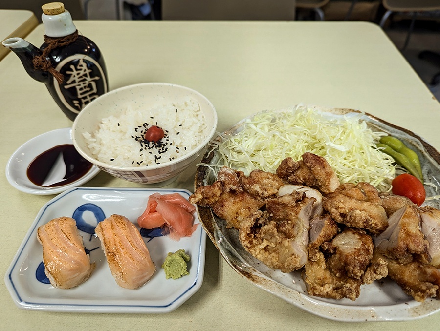 Fried chicken, rice, and a couple pieces of sushi.