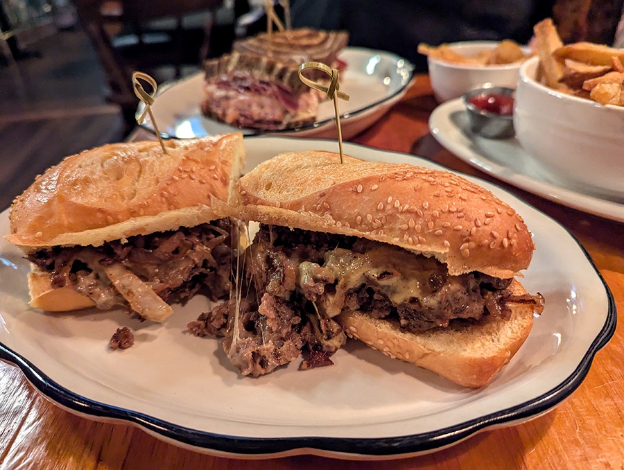 A sub roll is stuffed full of shaved steak and melty cheese.