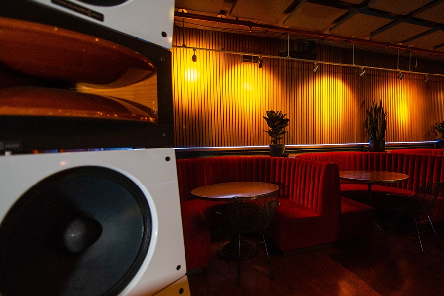 Interior of a bar with red velvet round booths.