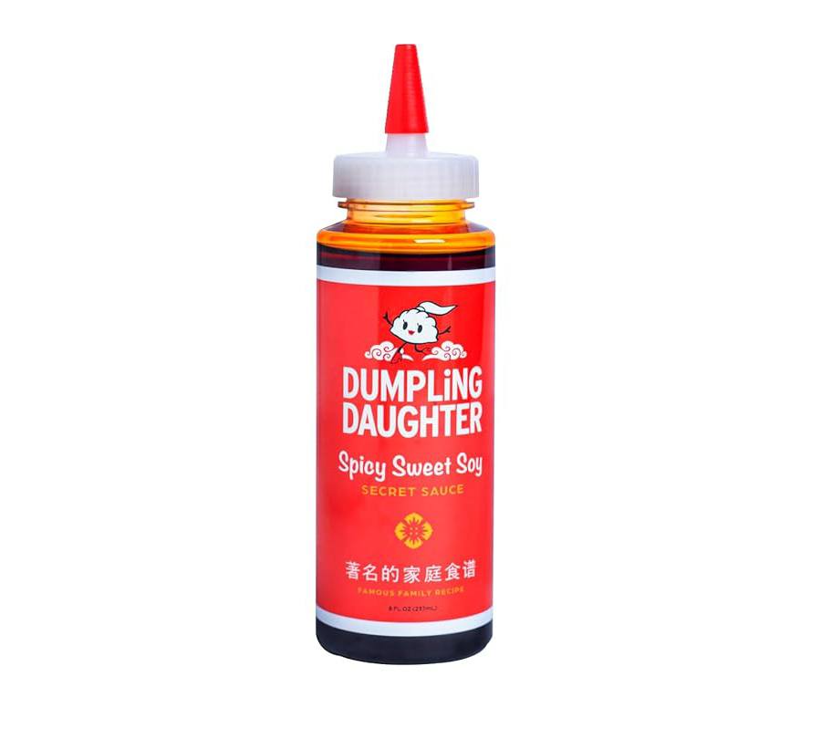 A squeeze bottle of a dark brown sauce with a red label with Dumpling Daughter branding.