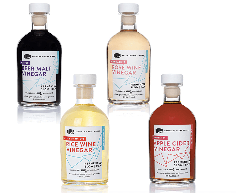 Four different vinegar bottles are isolated on a white background.