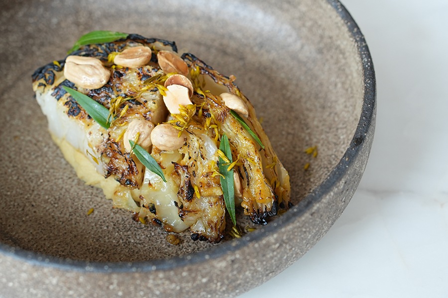 Charred cabbage is topped with chickpeas and herbs.