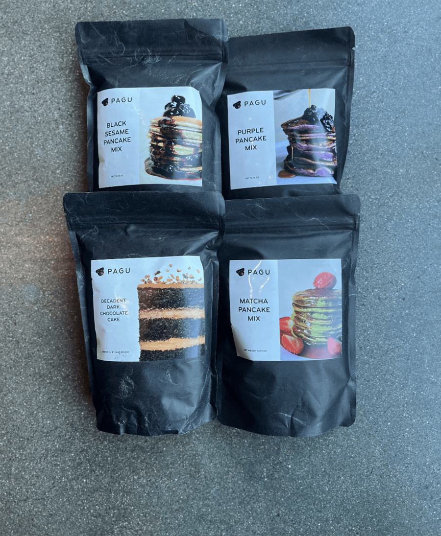 Four black bags with a different picture of pancakes or cake on each.