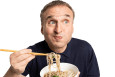 A man uses chopsticks to eat noodles from a bowl.