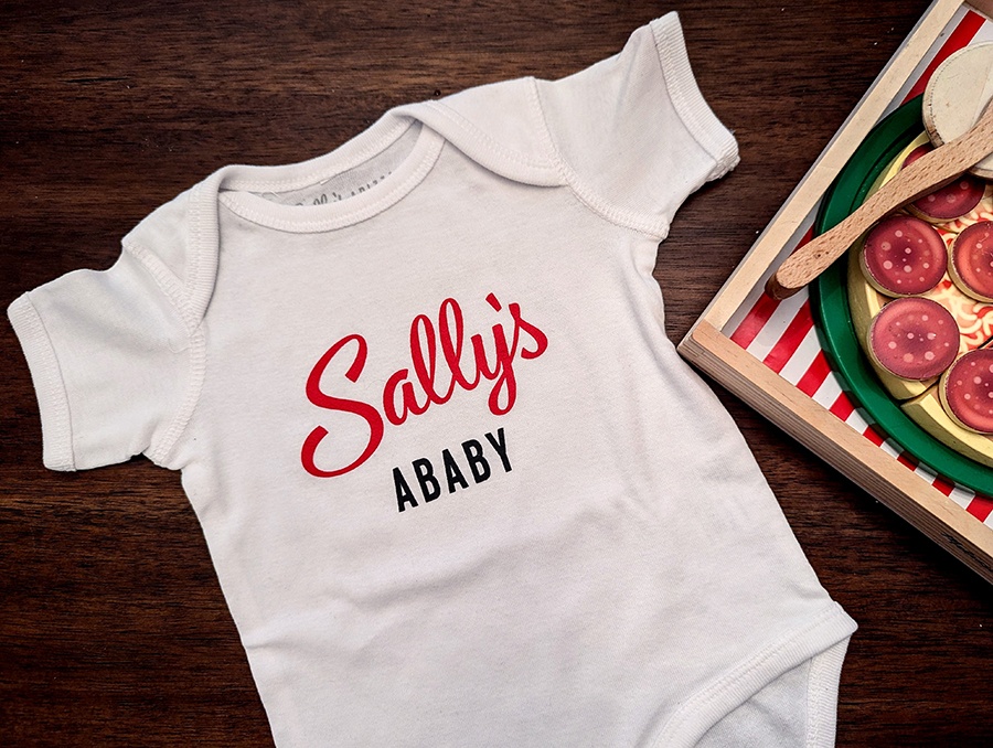 A onesie for a baby says Sally's Ababy.