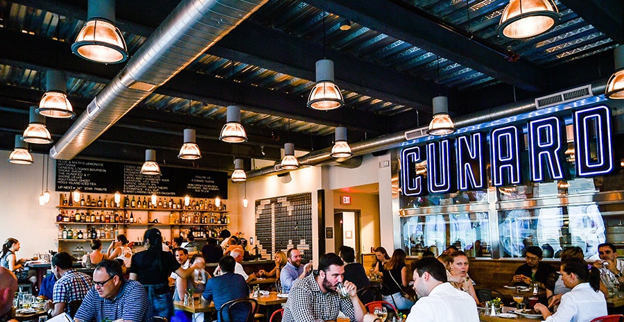 A casual restaurant with large letters reading "Cunard" is full of diners.