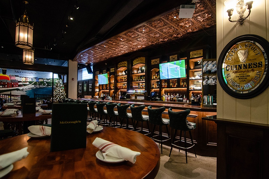 An Irish pub interior with a shiny Guinness plaque and intricate woodwork.