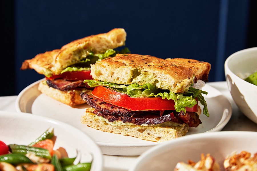 A sandwich with bacon, romaine, and tomato on focaccia.