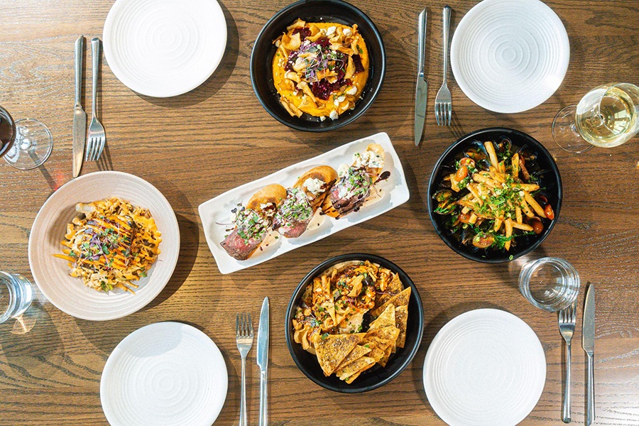 Overhead view of a wooden table covered with small plates of food.
